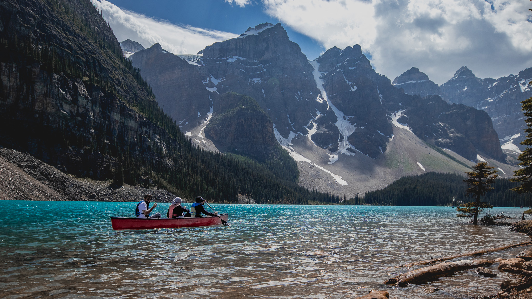 Jagged peaks tower above brilliant turquoise waters at Lake Moraine. As you sit and quietly contemplate their shapes and color, canoes provide a soft thump, clank, and splash, alongside the gentle break of waves against the shore.